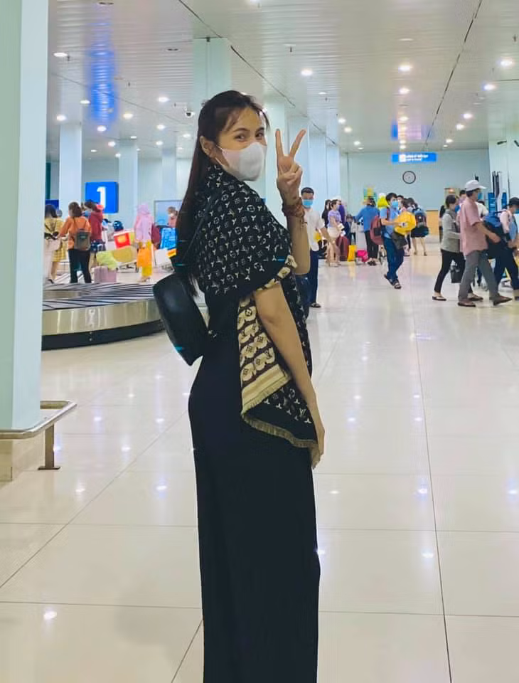 Thủy Tiên giấu chồng - ông xã Công Vinh để lên đường bay ra Huế hỗ trợ lũ lụt. Cô diện một cây đồ màu đen và khoác chiếc khăn để giữ ấm cơ thể.