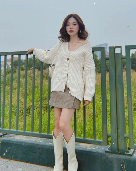 Áo ống, chân váy giả quần, cardigan cùng boots cao bồi là những món đồ Linh Ngọc Đàm chọn diện trong ngày lạnh.