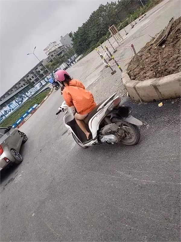 Nhiều người thắc mắc cô gái đi xe máy đang mặc quần đùi ngắn cũn hay chỉ mặc mỗi áo khoác nắng?