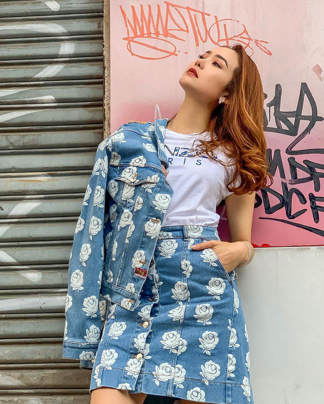 Minh Hằng lại đem lại ấn tượng khách biệt khi mix chân váy với áo phông Kenzo và khoác ngoài áo denim jacket cùng hãng.