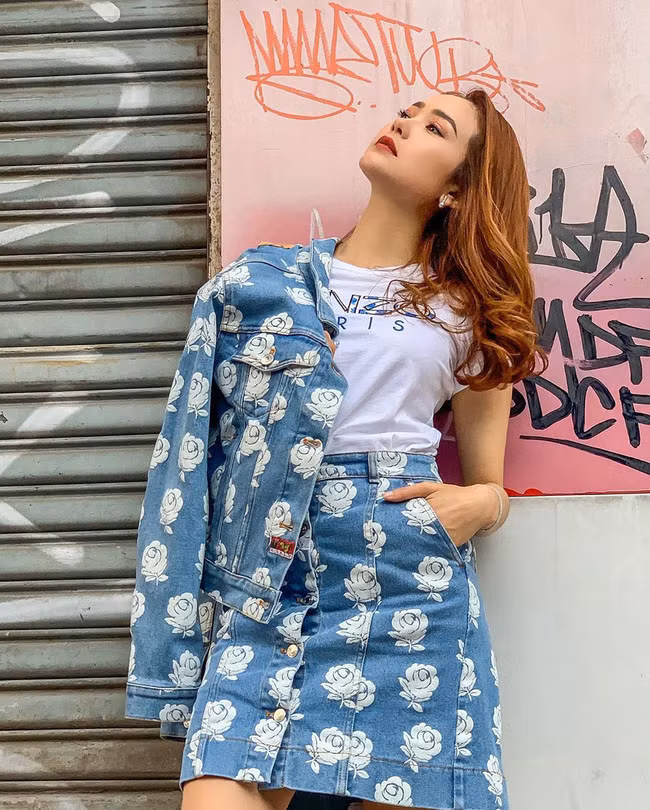 Minh Hằng lại đem lại ấn tượng khách biệt khi mix chân váy với áo phông Kenzo và khoác ngoài áo denim jacket cùng hãng.