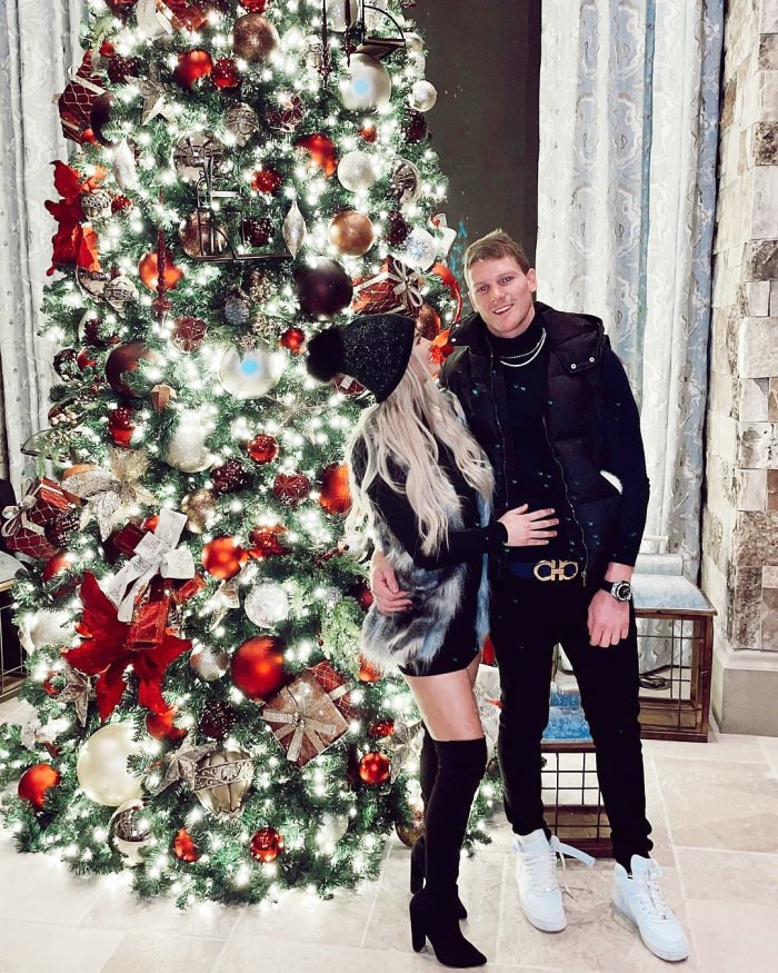 Nữ diễn viên Juliette Porter tạo dáng bên bạn trai Sam Logan trước cây thông Noel rực rỡ. Ảnh: Internet.