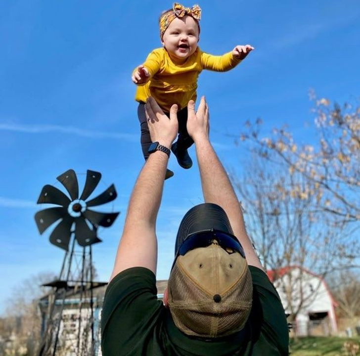 Cô bé thích thú khi được chơi trò tung hứng cùng bố.