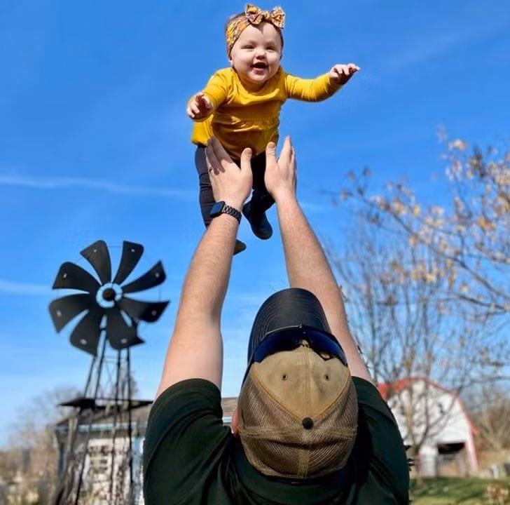 Cô bé thích thú khi được chơi trò tung hứng cùng bố.