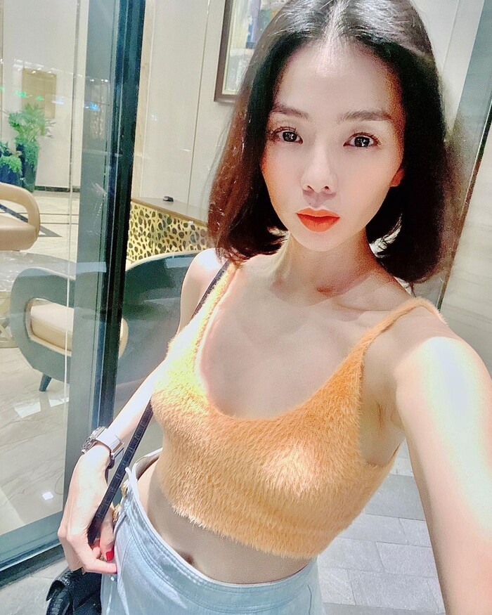 Áo croptop hai dây chất liệu lông mang tông màu cam cực kỳ nổi bật trên làn da trắng.