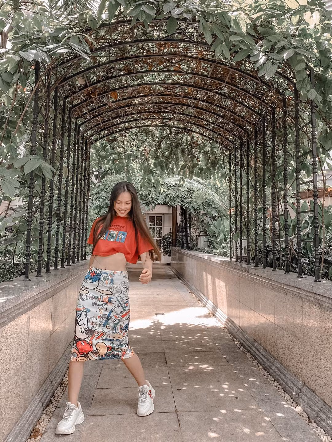 Hiền Thục khéo léo khoe eo thon với áo croptop dáng rộng và chân váy bút chì họa tiết vui mắt.