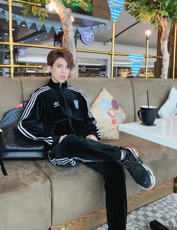 Anh chàng trông năng động và trẻ trung với bộ đồ thể thao đen từ đầu đến chân.