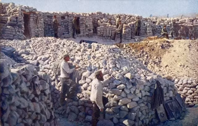 Các binh sĩ đứng xung quanh một hố bom lớn trên chiến trường Thế chiến 1.