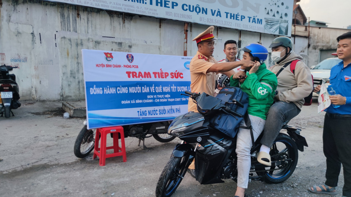 Đại uý CSGT Phan Thành Nghĩa tuyên truyền cho người tham gia giao thông về việc đội mũ bảo hiểm đúng quy cách và đảm bảo chất lượng.