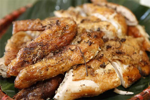 Gà nướng mắc khén là món ăn rất nổi tiếng của người Thái ở vùng Tây Bắc, trong đó có Điện Biên. Khi chế biến món ăn này, đầu bếp chọn gà ngon làm sạch, sau đó đem nướng. Gà nướng mắc khén có da vàng, thịt thơm, vị ngọt, đậm mùi mắc khén, xả, gừng, ớt. Ảnh: TTXVN.