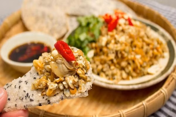 Bánh đa xúc hến là món nhậu quen thuộc của người dân xứ Nghệ. Hến được lấy từ dòng sông Lam đem đi tách vỏ, xào cùng mỡ hành, béo ngậy và thơm lừng. Ảnh: Reviewnao.com.