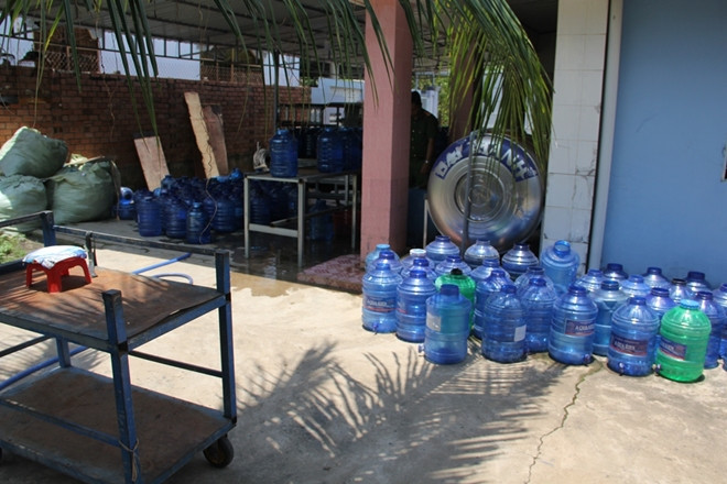 Đáng lưu ý, ở cơ sở này hiện đang sản xuất 3 loại nước uống đóng chai hiệu Aqua Kien (loại 20 lít) có địa chỉ sản xuất tại xã An Thạnh, huyện Bến Cầu; nước uống đóng chai hiệu Huy Hoàng loại 1.500ml có địa chỉ sản xuất tại huyện Châu Thành, An Giang và nước uống đóng chai hiệu Suối Rồng loại 350ml, địa chỉ sản xuất tại TP Hải Phòng. Làm việc với cơ quan chức năng, ông Kiên đã không cung cấp được hồ sơ công bố công nhận 3 nhãn hiệu này; không có giấy đủ điều kiện vệ sinh an toàn thực phẩm. (Ảnh: CAND). 