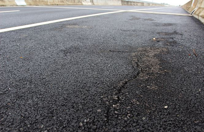 Mặt đường tiếp giáp trước mố cầu xuất hiện đường nứt dài hơn 1 m, rộng 1 cm.