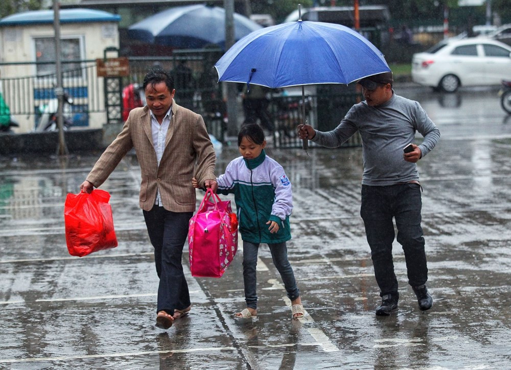 Người dân đến các bến xe trong cảnh mưa, rét.