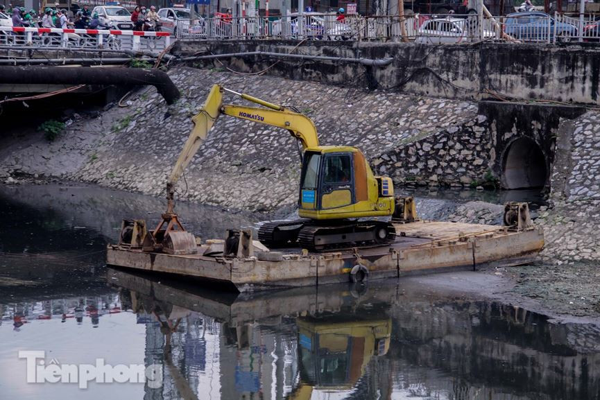 Máy múc được huy động đến để đưa bùn đất từ lòng sông lên, nhằm khơi thông dòng chảy. Tuy nhiên nước sông vẫn luôn trong tình trạng đen kịt.