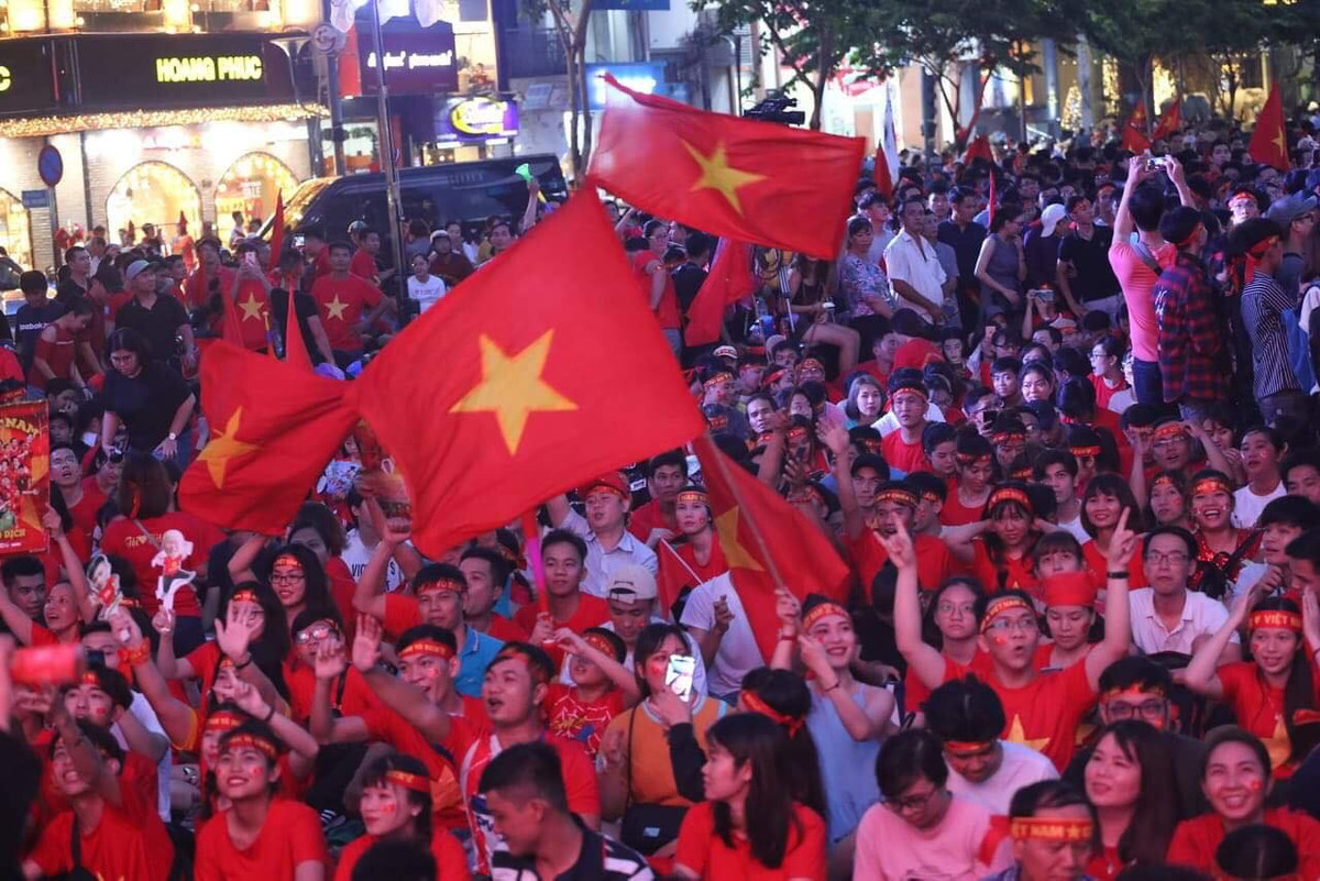 Cờ đỏ sao vàng được dơ cao, tung bay trong bóng đêm