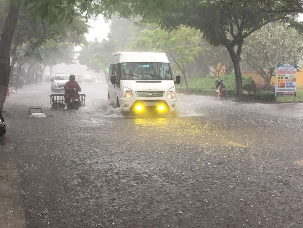 Xe khách bật đèn chạy trong mưa.