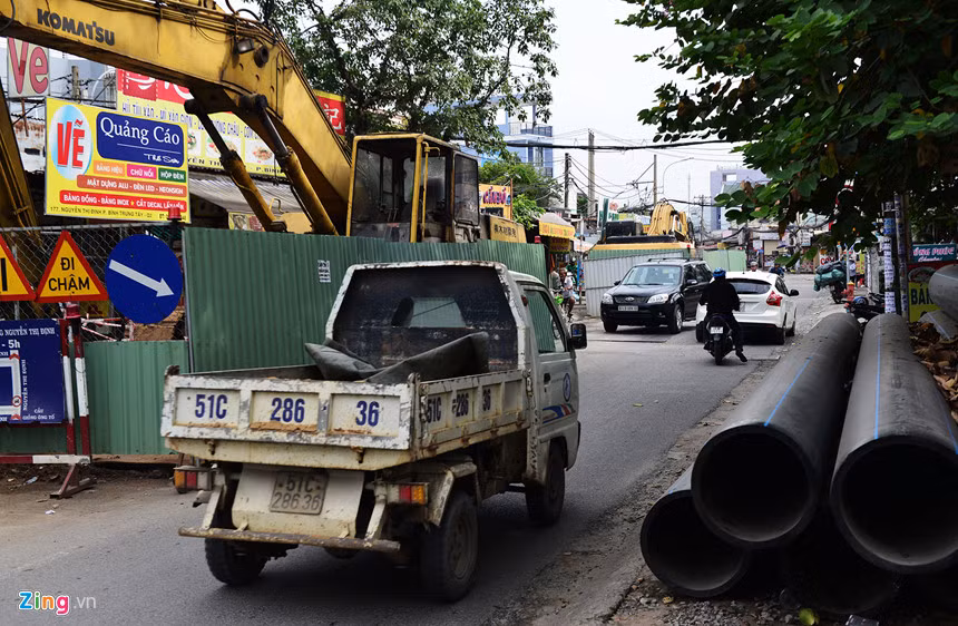 Tại đường Nguyễn Thị Định (quận 2), dự án Vệ sinh môi trường thành phố giai đoạn 2 hiện có 4 lô cốt đang án ngữ 1/2 mặt đường, trong đó 3 rào chắn "nhốt" máy cuốc nằm bất động bên trong. Bà Cao Thị Hương, chủ quán ăn tại đây cho biết công trình này đã ngừng thi công khoảng 2 tháng nay.