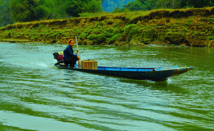 Ở vùng sơn cước, người phụ nữ có thể lướt chiếc xuồng bé trên mặt hồ một cách điêu luyện. (Ảnh: Long Trọng)