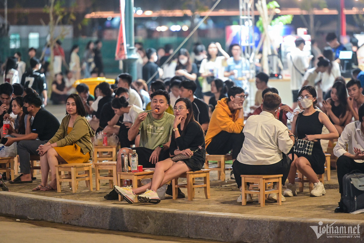 Trong không khí mát mẻ, rất đông bạn trẻ ngồi trước một quán cà phê tại công viên cùng chuyện trò.