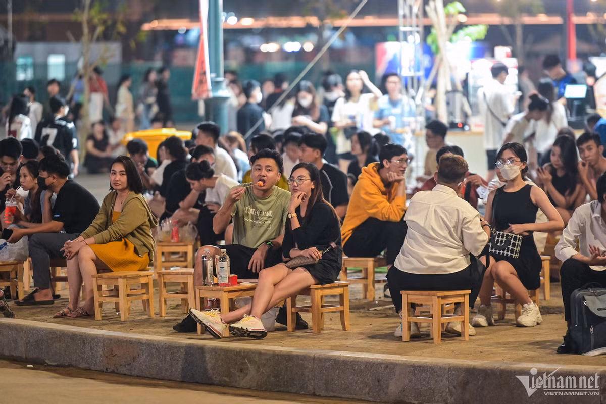 Trong không khí mát mẻ, rất đông bạn trẻ ngồi trước một quán cà phê tại công viên cùng chuyện trò.