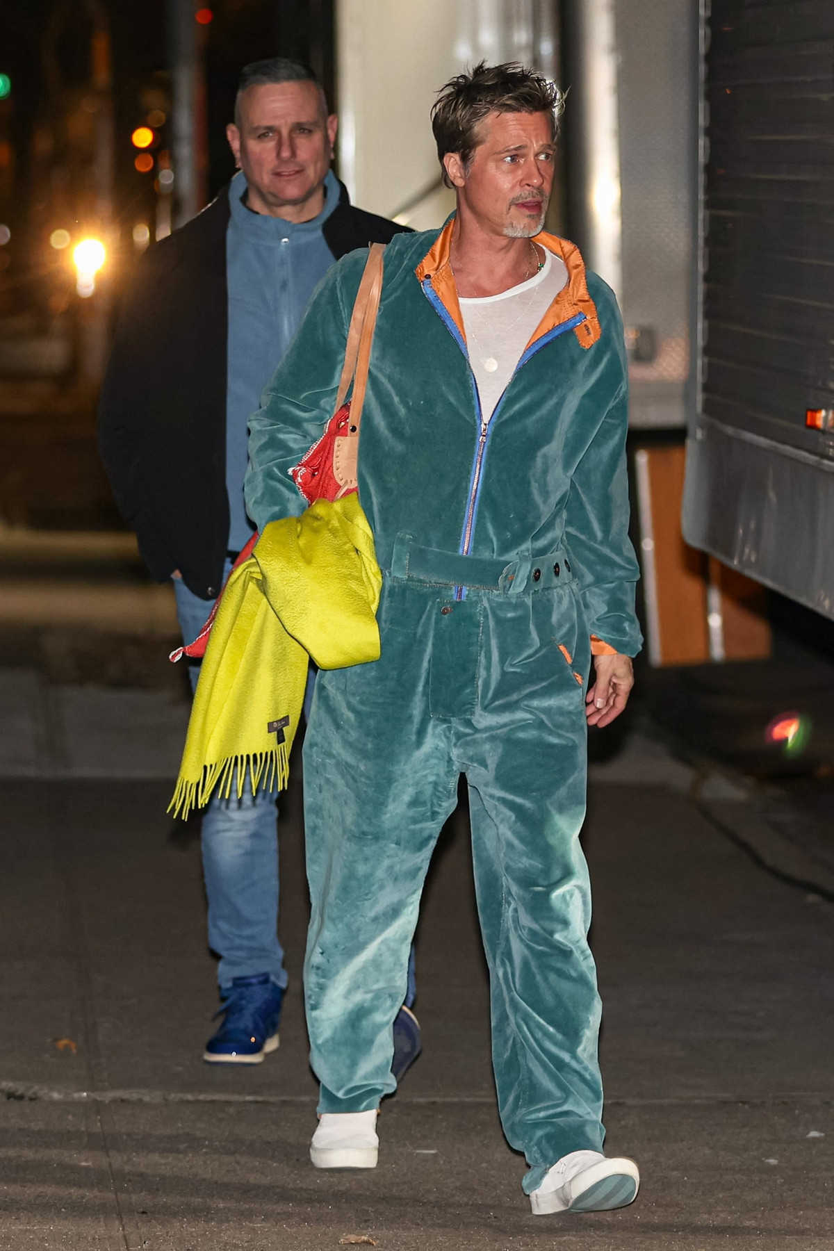 Bộ jums vải nhung màu xanh được coi là một trong những bộ trang phục trẻ trung và phá cách nhất của nam diễn viên Hollywood. Để tổng thể trở nên nổi bật hơn, Brad Pitt dùng túi màu cam đỏ, khăn quàng xanh neon của Loro Piana.