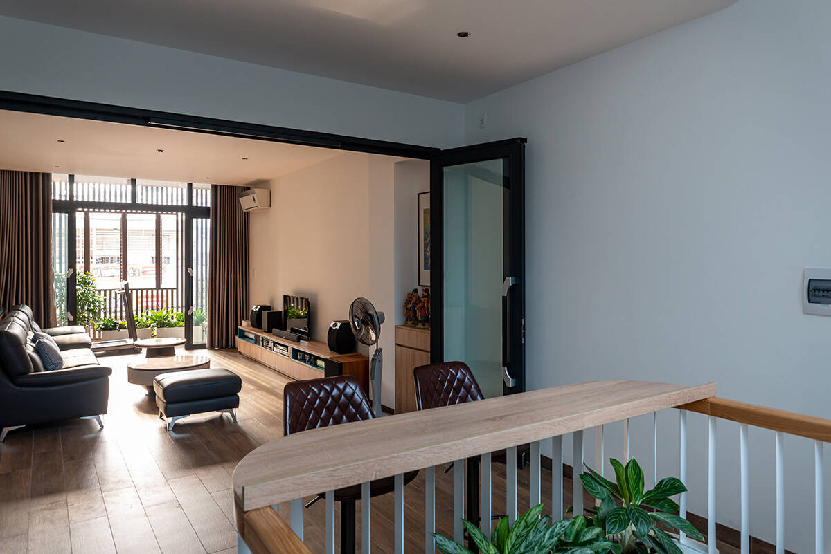 Nội thất được tinh giản để dành nhiều diện tích hơn cho các khoảng trống, lối đi. Phòng khách sử dụng hệ cửa kính trượt, đóng - mở linh hoạt để giữ gìn kết nối với ban công, sảnh thang, tạo nên một mặt bằng rộng mở, thông thoáng.