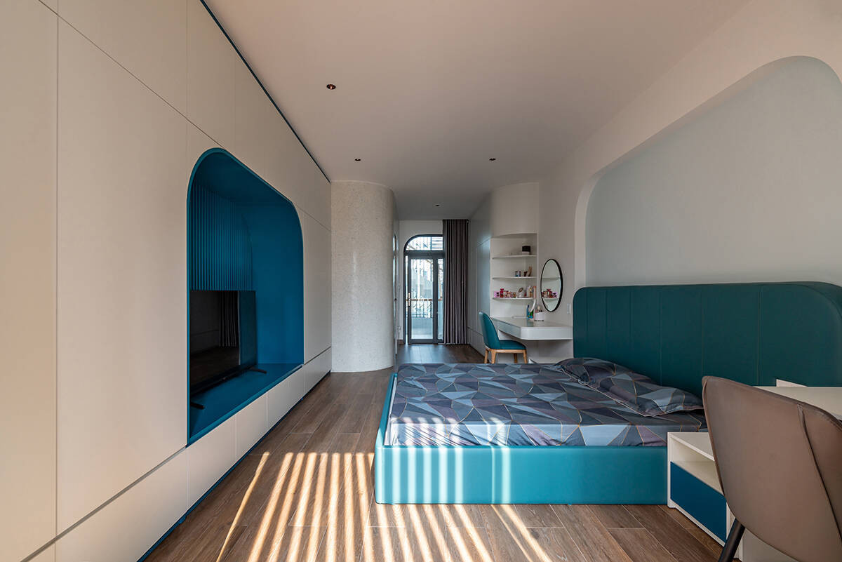 Gia chủ là người Việt gốc Hoa nên yêu cầu phối thêm màu xanh để phù hợp với văn hóa tín ngưỡng. Ngoài ra, ban công phía trước phòng con được rút ngắn lại, có thể nhìn xuống ban công của phòng ngủ bố mẹ.