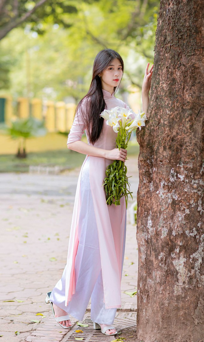 Nét đẹp dịu dàng của người con gái Hà thành bên bó hoa loa kèn trắng tinh khôi, tỏa hương thơm dịu dàng.