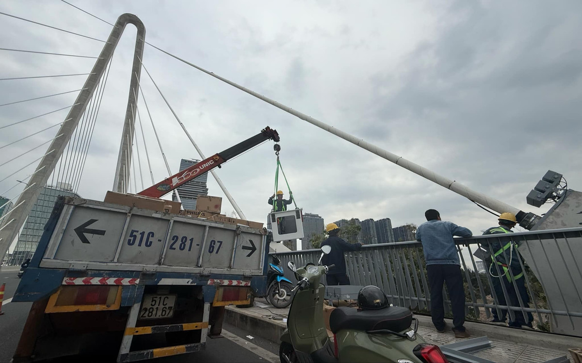 Theo ghi nhận của PV Tri thức và Cuộc sống, các nhân viên kỹ thuật lắp đặt các dàn đèn khá lớn, nhiều chi tiết…ngay các ụ dây văng giữa cầu.