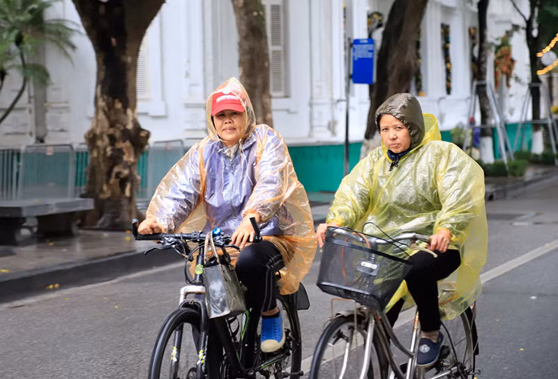 Dù trời rét kèm theo mưa, nhưng nhiều người vẫn mặc áo mưa đạp xe quanh khu vực hồ Hoàn Kiếm.