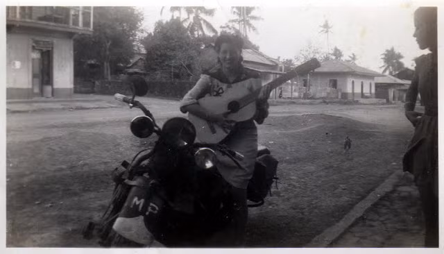 Thiếu nữ ngồi trên mô tô đánh đàn trên một góc phố của đất nước Panama. Ảnh VT