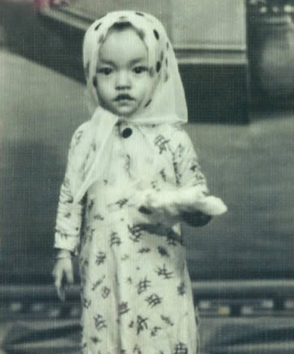 Hình ảnh nghệ sĩ Hương Lan năm 2 tuổi. Nữ ca sĩ chia sẻ: "Hương Lan được bà nội dẫn đi may áo dài. Hai bà cháu mỗi người một bộ giống nhau. Hương Lan cũng đội khăn cho giống bà nội luôn".