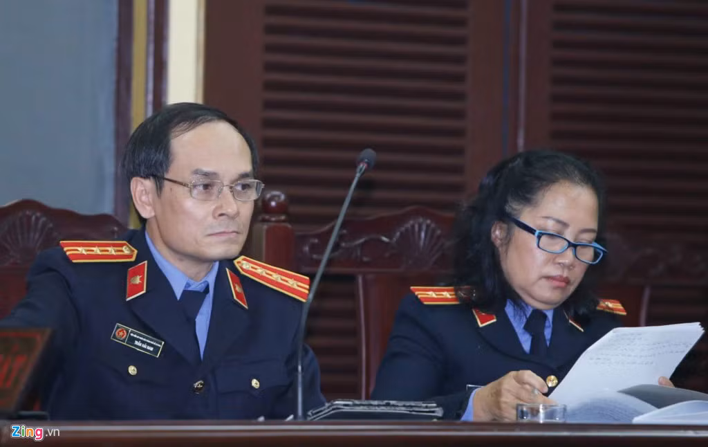 Đại diện VKSND tại phiên xử sơ thẩm sáng 22/6. Trước lời đề nghị hoãn phiên xử do vắng mặt nhiều người có quyền và nghĩa vụ liên quan, đại diện cơ quan công tố đã không đồng ý. 