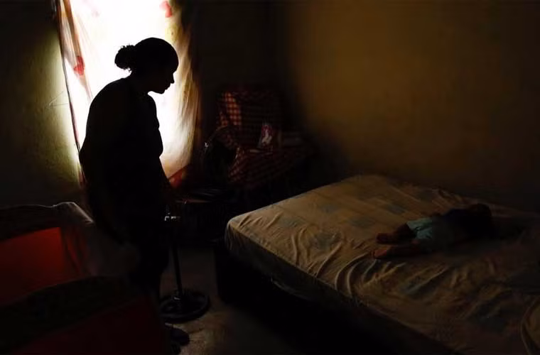 Chị Yelis Toussaint trìu mến nhìn cậu con trai đang ngủ Jhonanyel trước khi chị đi triệt sản.