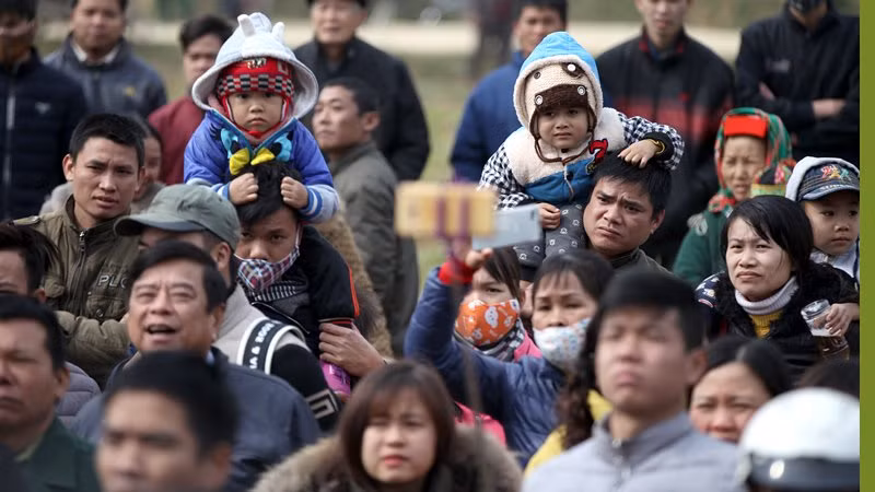 Không thể chen chân vào gần hơn, những đứa trẻ được người thân kiệu lên vai .