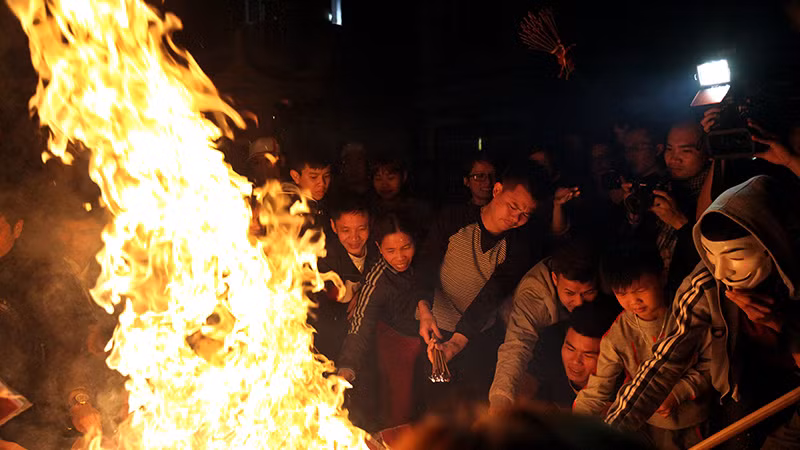 Chiếc mặt nạ được sử dụng để chống sức nóng hầm hập khi lao vào châm hương lấy lộc.