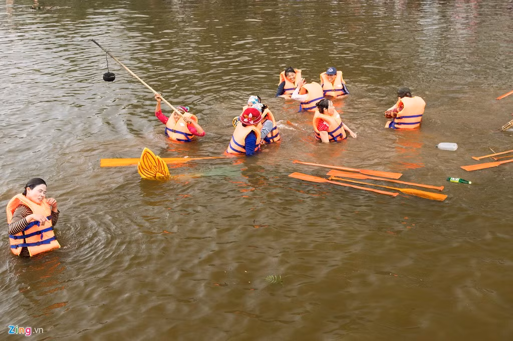 Chiếc thuyền chìm dần còn mái chèo nổi lênh đênh. Rất may con sông này không sâu, mọi người có thể lội được.