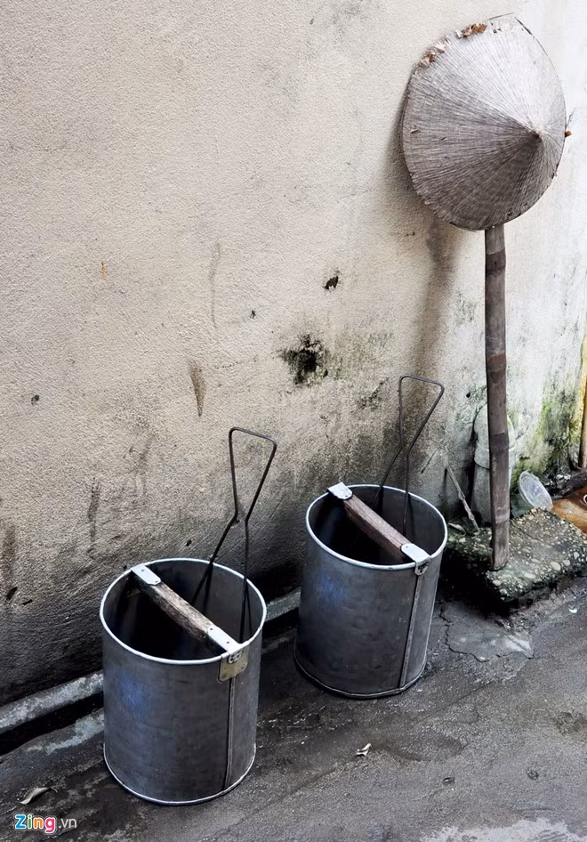 Sau buổi gánh nước thuê, ông Đường trở về nhà đặt đôi thùng nhôm cùng đòn gánh và chiếc nón lá cũ mèm bên con hẻm Trần Hưng Đạo (phố cổ Hội An).