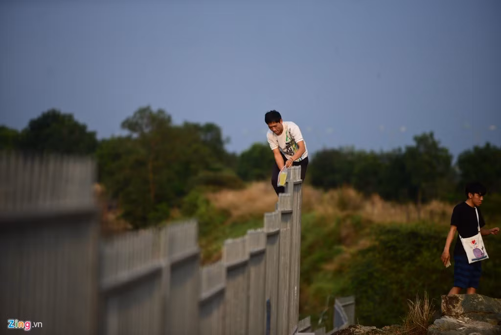 Không ít thanh niên còn trèo lên đỉnh qua các thanh sắt nhọn tua tủa để vào trong.