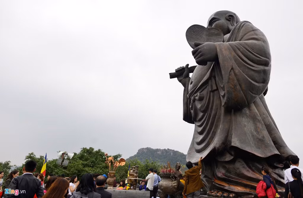 Trên đỉnh cao nhất của quần thể chùa Bái Đính, nơi đặt tượng đồng A Di Lặc, du khách dùng tay và tiền xoa lên bàn chân khiến bức tượng đổi màu.