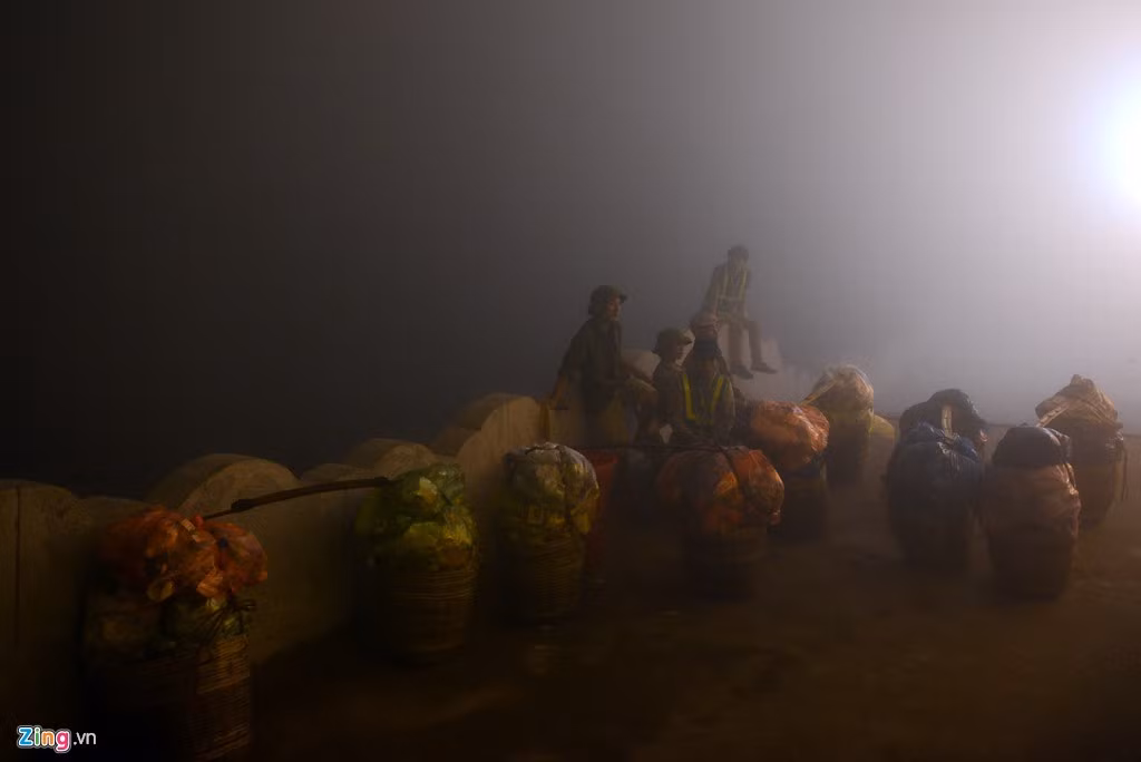 Công nhân môi trường ngồi nghỉ dọc đường trước khi gánh rác thải ngược đường trở về chân núi.