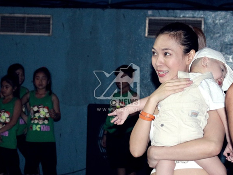 Mỹ Tâm vui vẻ khi bế một em nhỏ trong một buổi tập luyện. Ảnh: Yan