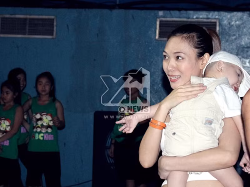 Mỹ Tâm vui vẻ khi bế một em nhỏ trong một buổi tập luyện. Ảnh: Yan