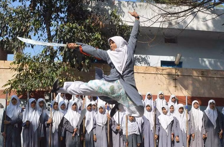 Các học sinh nữ bậc trung học ở Ấn Độ luyện đao, kiếm trong giờ tập võ thuật.