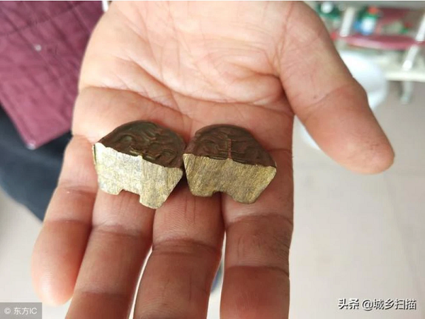 Quan sát kỹ hơn, vật thể này có màu vàng đồng, bên trên và dưới thỏi vàng này có khắc hoa văn đối xứng với nhau. Đặc biệt, ở dưới đáy còn có thêm 1 vết lõm.