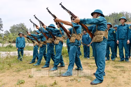 Nữ chiến sĩ dân quân phường Phùng Chí Kiên (TP Bắc Kạn) thực hiện động tác khám súng trước giờ huấn luyện bắn súng. Ảnh: QĐND.