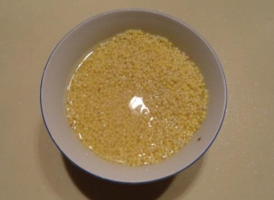 Bước 1: Hãy rửa hạt kê sạch sẽ. Sau khi rửa sạch, chuẩn bị một cái tô, cho nước lạnh vào tô rồi ngâm kê trong tô khoảng 30 phút để kê ngấm ít nước sẽ chín mềm hơn. Mọi người có thể ngâm hạt kê trước sẽ tiết kiệm thời gian hơn.