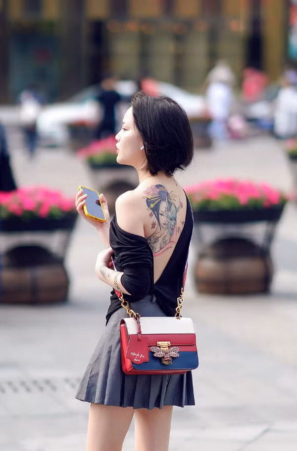 Giống như người phụ nữ trẻ ở trên, Zi Ān, 24 tuổi, sinh sống tại Bắc Kinh, Trung Quốc cũng từng trở thành tâm điểm chú ý của mọi người khi để lộ hình xăm lớn xuống phố.