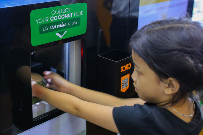 Dừa sẽ được vận chuyển xuống khay đựng để khách hàng có thể dễ dàng nhận được.